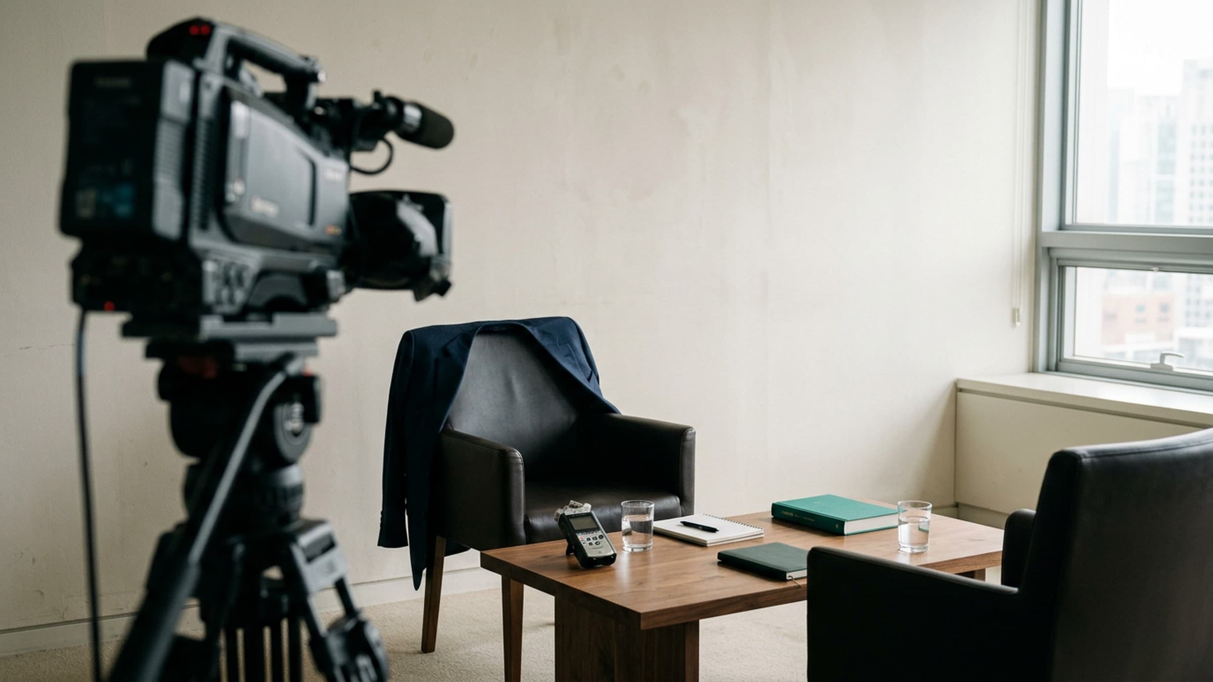 One-on-one executive interview set up with two chairs angled toward each other under soft studio lighting